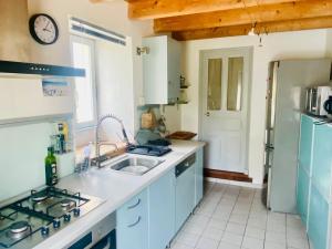 a kitchen with blue cabinets and a sink at Chaleureuse Maison à Groix, 5 pers, 3 chambres - FR-1-813-31 in Groix +9 photos