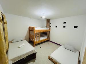 a small room with two beds and a desk at Casa Almanik Hostel in Medellín
