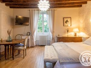 une chambre avec un lit, une table et une fenêtre dans l'établissement Chambres d'hôtes spacieuses près de la Loire - FR-1-622-116, à La Menitré
