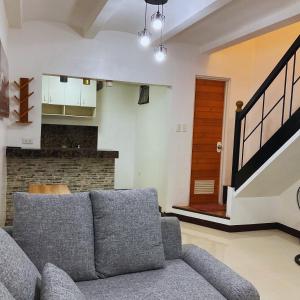 een woonkamer met een bank en een trap bij JeSa's Serenity Sanctuary in Dasmariñas