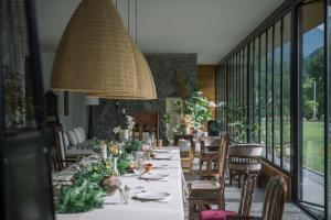 une salle à manger avec une longue table et des chaises dans l'établissement Yunfu Mid Hill Resort Hote, à Honghuaping