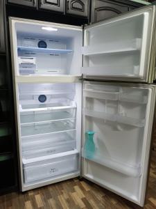 Un refrigerador vacío con la puerta abierta y un jarrón dentro. en Club Campestre Champagne, en Chachagua
