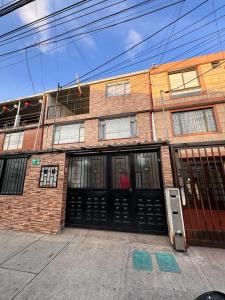 a brick building with black doors on a street at Hostel Villa luz tu sitio in Bogotá