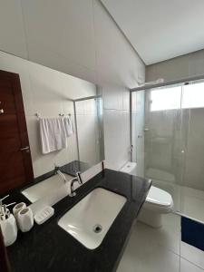 a bathroom with a sink and a toilet and a shower at Condomínio Vila do Mar in Luis Correia