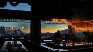 a restaurant with a view of the mountains at Rifugio Orso Bruno in Commezzadura