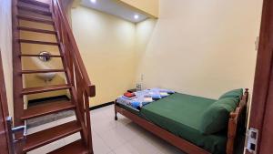 a small room with a bunk bed and a ladder at Homestay RnJ in Licin