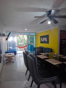 a dining room with a table and chairs and a ceiling fan at Patuca Balcon in Rodadero +8 photos