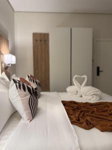 a large white bed with two pillows on it at Marvin Suites in Al Wajh