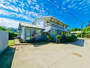 ein weißes Haus mit einer Auffahrt davor in der Unterkunft Nuku'alofa Town Cottage - Entire Place Upstairs Only in Nuku‘alofa