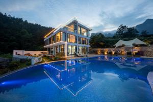 a house with a pool in front of it at Zhangjiajie Flowers Valley,Watching Sunrise Cloud Sea, enjoying an infinity pool, free Chinese and Western breakfast, and free shuttle service to the entrance of the National Forest Park in Zhangjiajie