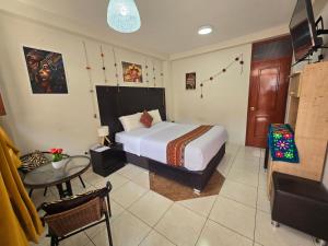 クスコにあるCusco Roomsの部屋にベッドとテーブルがある寝室