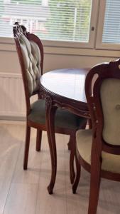 a dining room table and two chairs and a table and chairs at LUXE, by Ilona Apartments in Kotka