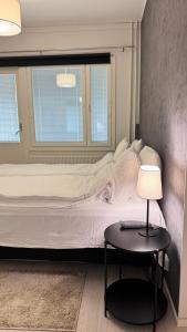 a bedroom with a bed and a table with a lamp at LUXE, by Ilona Apartments in Kotka +46 photos