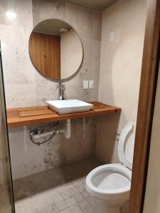 a bathroom with a white toilet and a mirror at Suite Reforma in Oaxaca City