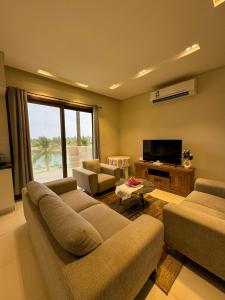 a living room with two couches and a flat screen tv at هوانا ڤيو - Hawana view in Ma‘mūrah