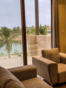 a living room with two chairs and a large window at هوانا ڤيو - Hawana view in Ma‘mūrah