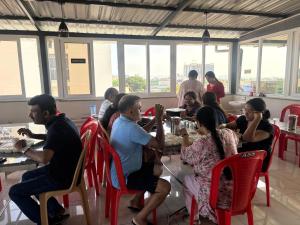 a group of people sitting at tables in a restaurant at KK Grand Inn in Vellore