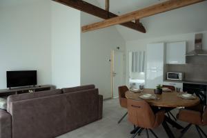 a living room with a table and a couch at Brussels North - Pajot Apartments in Wemmel
