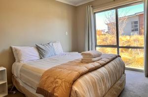 a bedroom with a bed and a large window at Askray Apartment - Lake Tekapo in Lake Tekapo