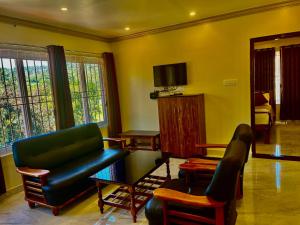 a living room with a couch and a chair at Lakshmi Flower Tech Resort in Yelagiri