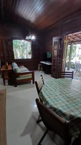 a room with a bed and a table with a green blanket at Casa de madeira A 6km de Guaramiranga in Pacoti +25 photos