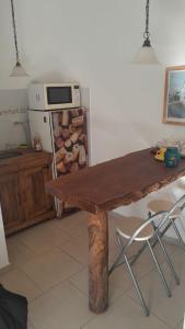 une cuisine avec une table en bois et un micro-ondes dans l'établissement La Ponderosa, à Veinticinco de Mayo
