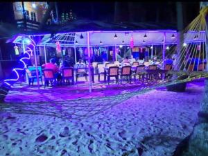 un grupo de personas sentadas en un restaurante por la noche en Samant Beach Resort, en Malvan