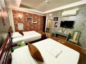 a hotel room with two beds and a television at Cozi Hotel in Hai Phong