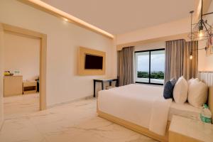 a bedroom with a bed and a large window at Lemon Tree Hotel, Erode in Erode