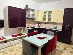a kitchen with a table and red chairs in it at The contineltal in Pachino