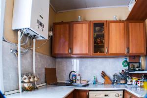 una cocina con armarios de madera y fregadero en Homestay Nika en Tiflis