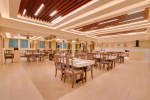 a large dining room with tables and chairs at Lemon Tree Hotel, Erode in Erode