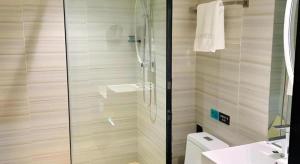 a bathroom with a shower and a toilet and a sink at Xana Lite Korla Xiangli Avenue Food Street in Korla +127 photos