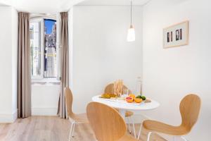 a white dining room with a white table and chairs at LSA Ascensor da Bica by Numa in Lisbon