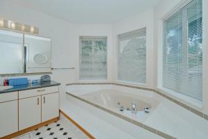 Duża biała łazienka z wanną i oknami w obiekcie Tsawwassen 3 Bedroom Ground Suite w mieście Delta