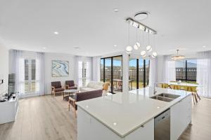 a kitchen and living room with white walls and windows at Stylish & Spacious 3BR 2BA Home in Spring Mountain M28 in Springfield Lakes