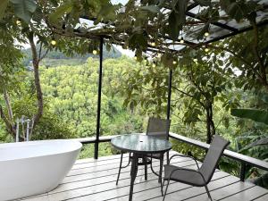 a bathroom with a tub and a table and chairs on a deck at One villa coffee farm stay 1 in Ban Huai Khai