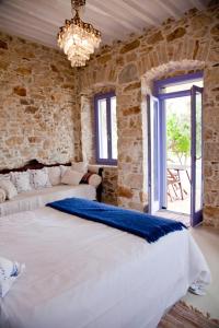 PosidhoníaにあるGood Life Greece Eco Villasの石壁のベッドルーム1室(大型ベッド1台付)