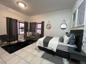 a bedroom with a bed and a couch and a chair at The Lagoon in Pretoria +50 photos