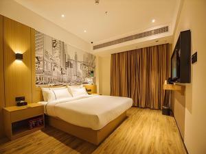 a hotel room with a bed and a television at City Comfort Inn Yangjiang High-tech Zone Pinggang in Yangjiang