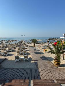 a sandy beach with lounge chairs and the ocean at Apartment Skу in Kavarna