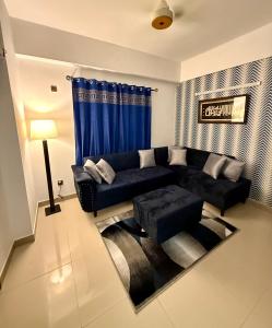 a living room with a black couch and blue curtains at 1BR Cozy Apartment, Diamond Mall & Residencia, Islamabad in Islamabad
