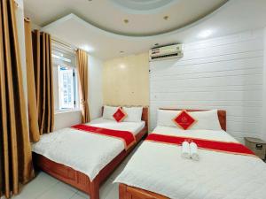 two beds in a small room withskirts at Khách Sạn Ngọc Hà in Ho Chi Minh City +4 photos