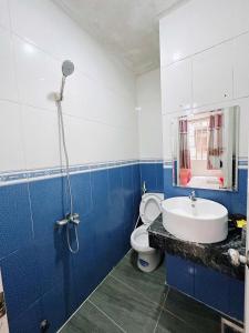 a blue and white bathroom with a toilet and a sink at Khách Sạn Ngọc Hà in Ho Chi Minh City