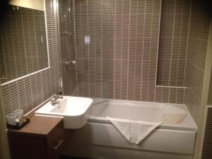 a bathroom with a sink and a bath tub and a sink at The Greyhound Hotel Cromford in Cromford