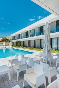 uma imagem de um resort com cadeiras brancas e uma piscina em Vila Baleira Village em Porto Santo