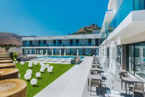 an exterior view of a building with chairs and umbrellas at Vila Baleira Village in Porto Santo
