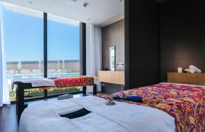 a bedroom with two beds and a large window at Vila Baleira Village in Porto Santo