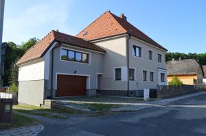 une maison blanche avec un toit marron dans l'établissement Apartmán Monty, à Žulová