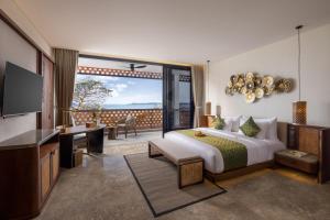 沙努尔Sumitra Luxury Villas & Resort by Pramana的带床和阳台的酒店房间